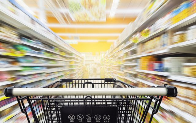 Supermarket aisle with empty black shopping cart